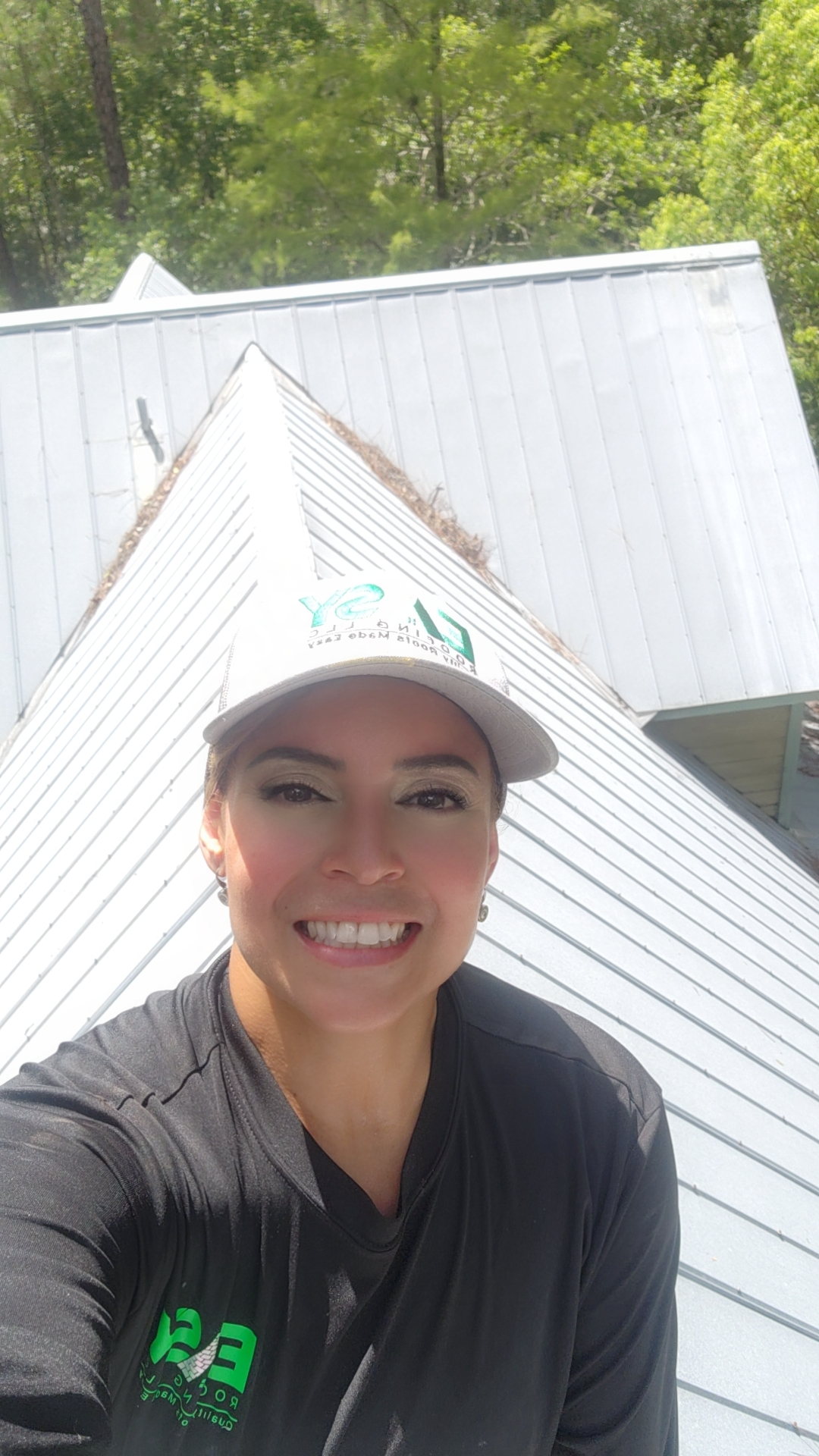 Easy Roofing LLC employee posing on metal roof ridge